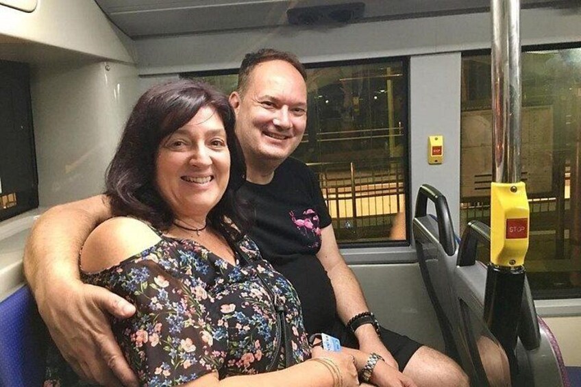 Two people sitting on a train seat with a window in the background. 5