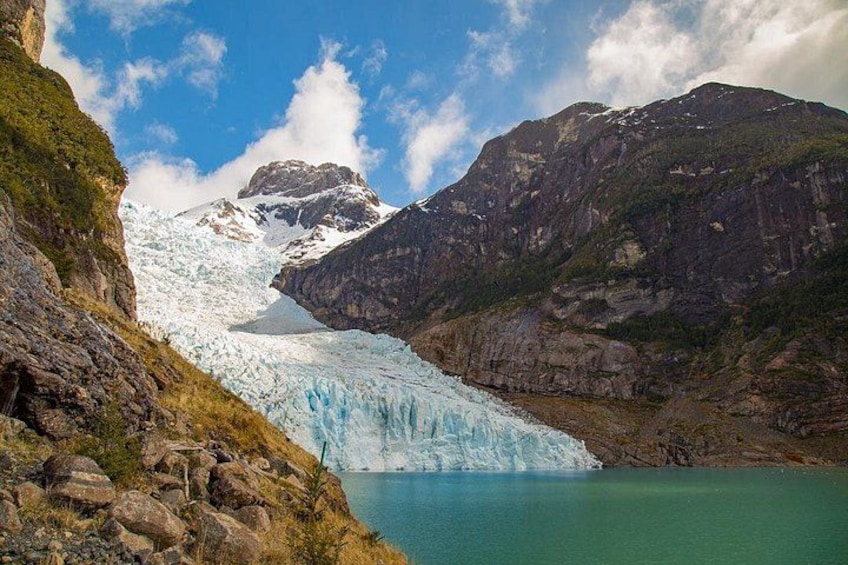 Un glaciar con un lago turquesa, montañas rocosas y un cielo despejado. 1