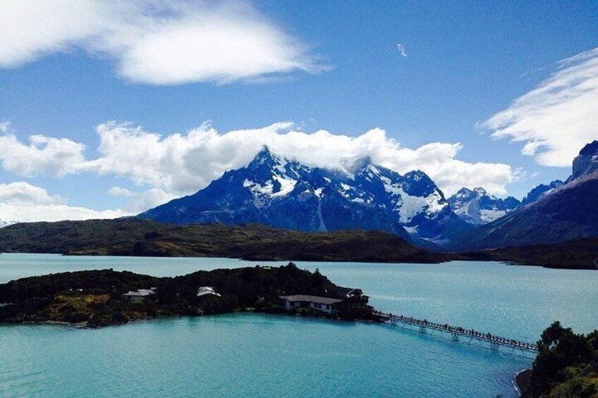 A lake surrounded by mountains, a dock, and a small building. 3