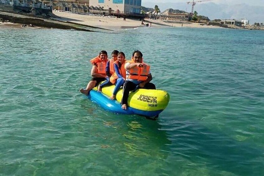 Un grupo de personas en un bote inflable azul y amarillo sobre aguas cristalinas. 3