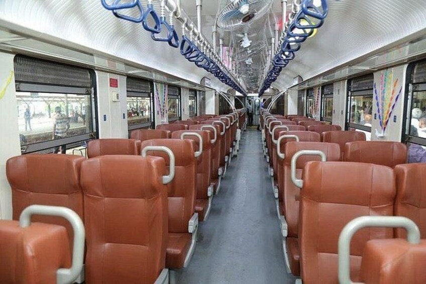 A train interior with rows of brown seats, overhead luggage racks, and windows. 4