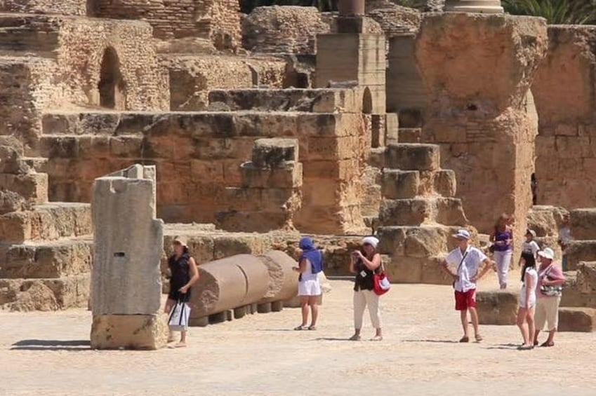 Ruinas antiguas con turistas caminando cerca. 3