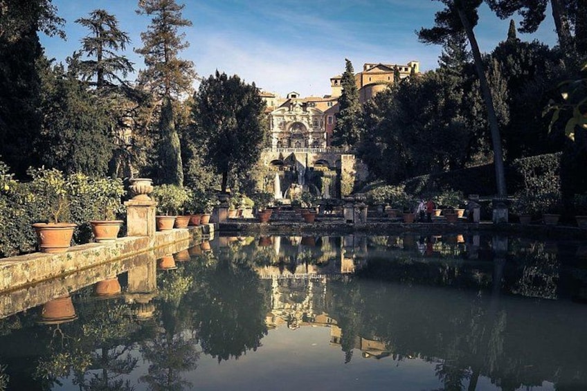 A tranquil garden with a reflective pond, terraced stone steps, and classical architecture in the background. 3