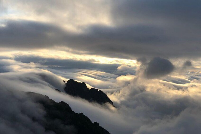 A mountain range with clouds below. 2