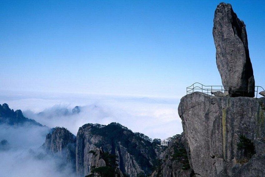 A rock formation with a viewing platform, surrounded by misty mountains. 1