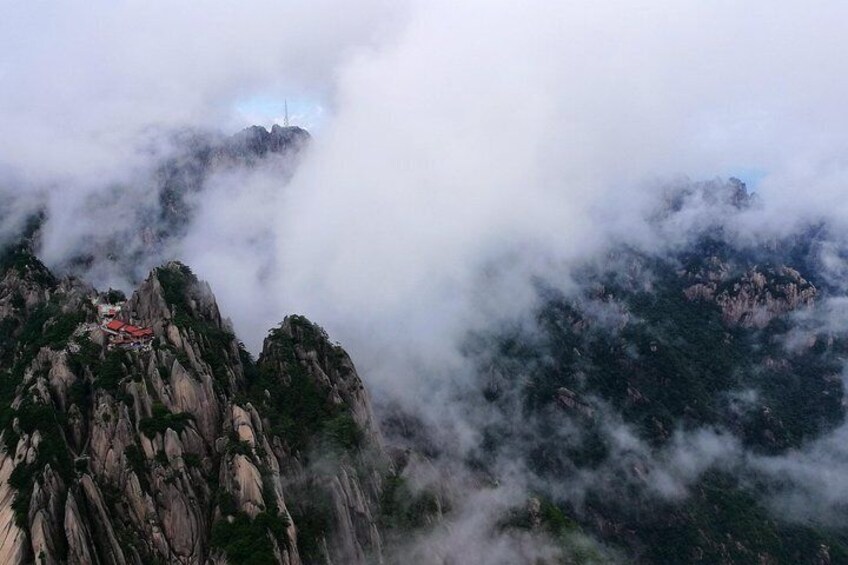 A mountainous landscape with a temple on a peak, surrounded by clouds. 5