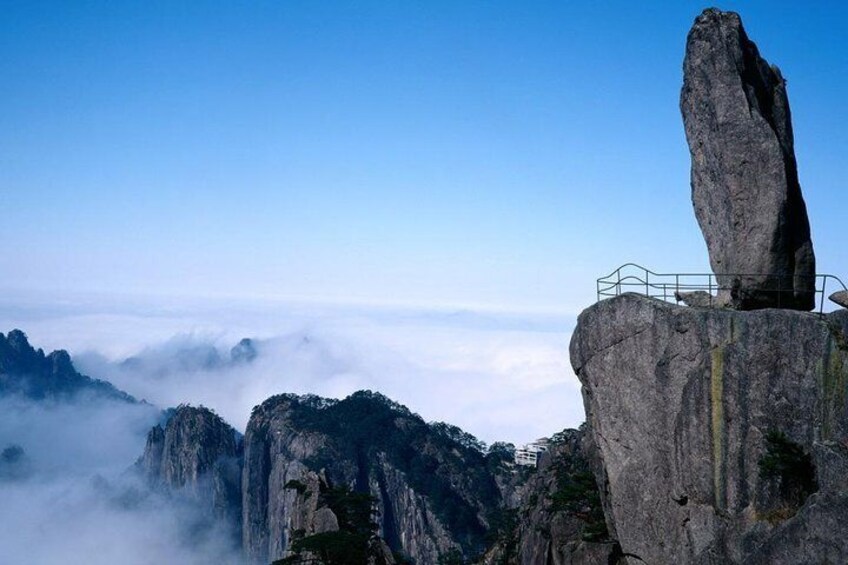 A rock formation with a viewing platform, surrounded by misty mountains. 1