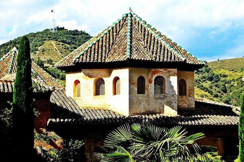 A traditional building with a tiled roof, arched windows, and a stone wall. 3