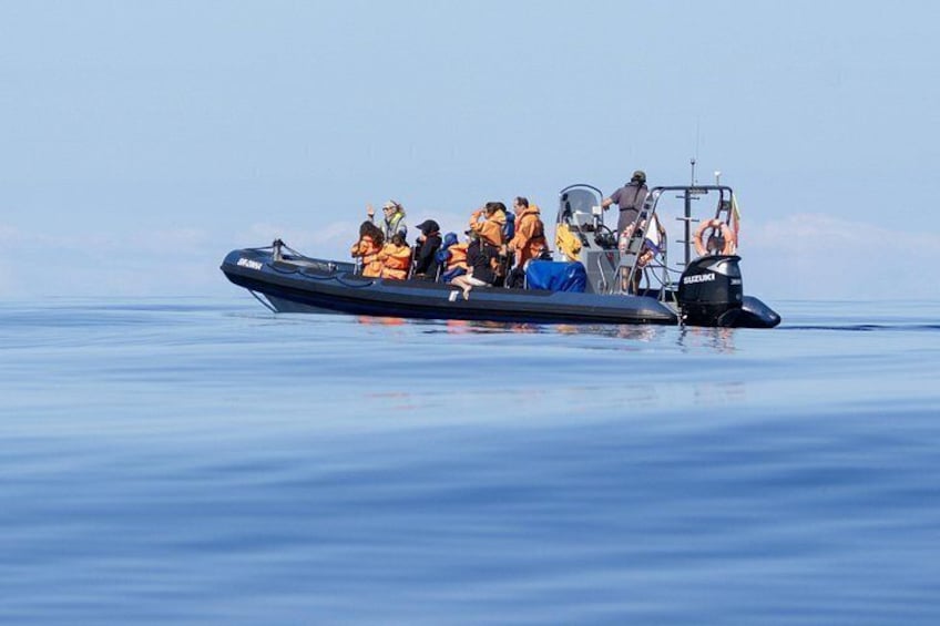 A boat with people wearing life jackets on calm water. 2