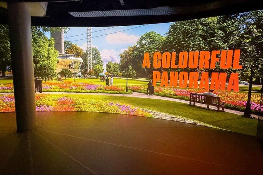Un panorama vivace di un parco con fiori, una panchina e un edificio sullo sfondo. 2
