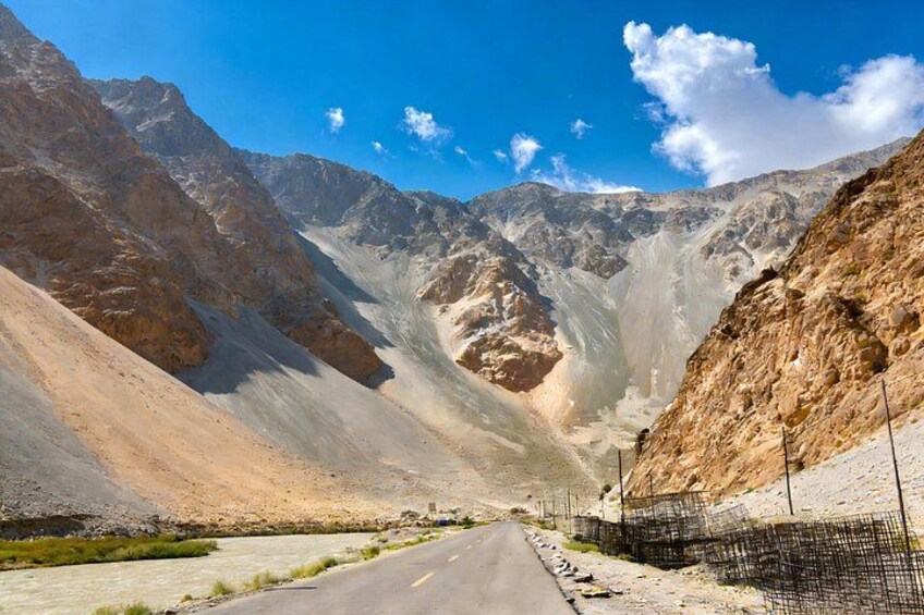 A road in a mountainous area with rocky terrain and sparse vegetation. 4