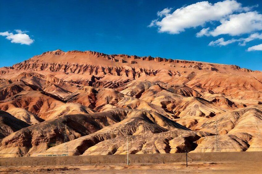 A desert landscape with layered rock formations and a clear blue sky. 5
