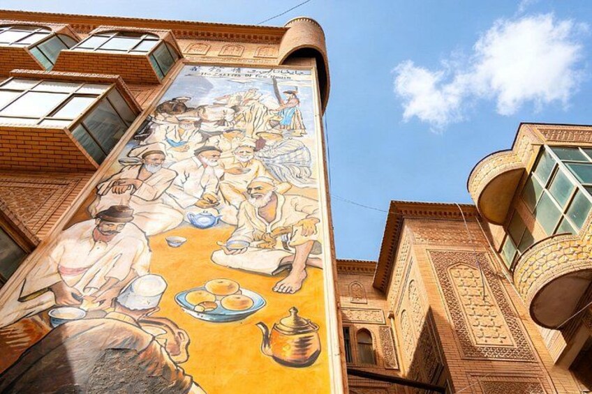 A mural of a traditional tea ceremony on a building's facade. 3