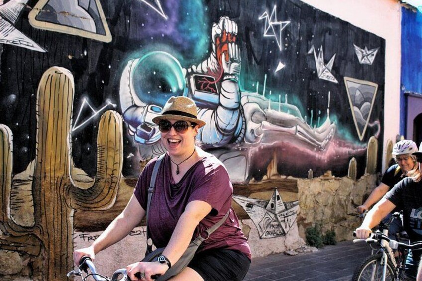En person cykler forbi en mural. 2