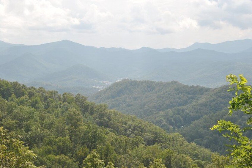 Un paisaje montañoso con bosques densos y cumbres distantes. 2