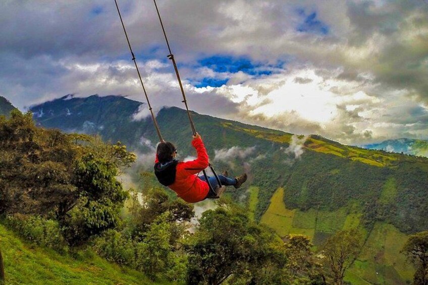 A person swinging on a rope over a mountainous landscape. 5