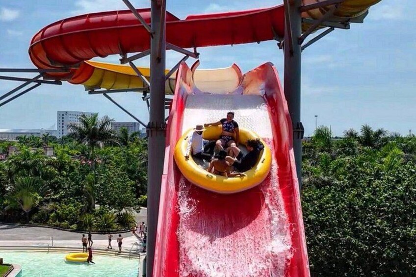 Une toboggan aquatique avec un tube jaune, un toboggan rouge et une personne en haut. 2