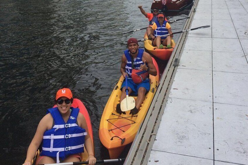 Tres personas en kayak en un muelle. 3