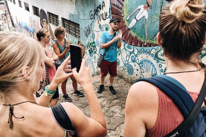 Un grupo de personas tomando fotos en un entorno urbano con grafitis en las paredes. 3
