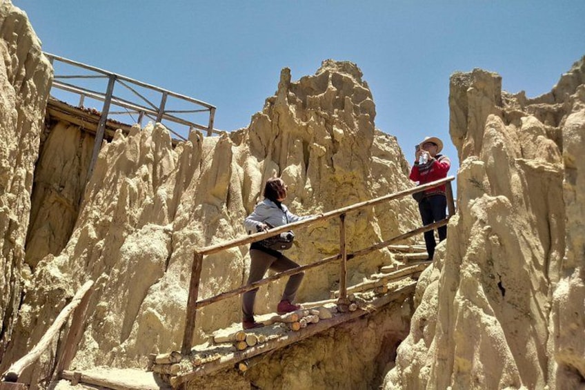 A person climbing a rocky staircase with a metal railing. 4