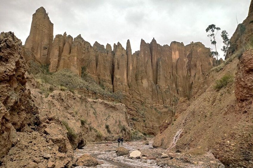 Un cañón con formaciones rocosas altas y esbeltas, y un pequeño arroyo. 3