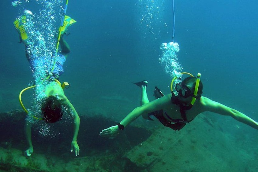 Dos buzos escafandrazos bajo el agua, con aletas y equipo de respiración. 4