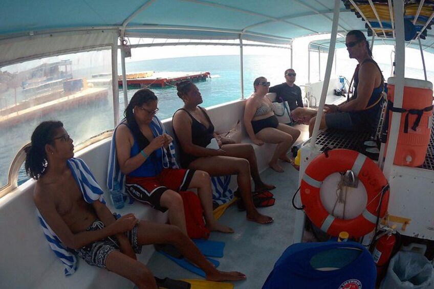 Personas en un bote con chalecos salvavidas y un flotador. 3