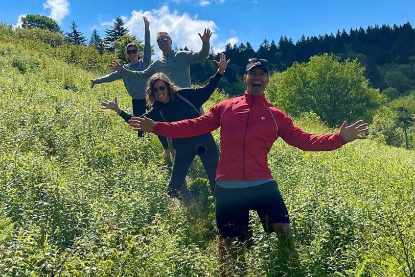 A group of people hiking in a grassy field with trees in the background. 2