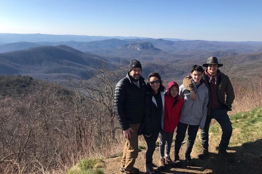 Un grupo de personas de pie en una colina con un paisaje montañoso al fondo. 5