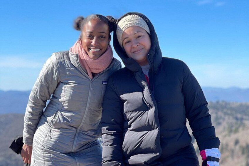 Dos personas de pie en una montaña bajo un cielo despejado. 4
