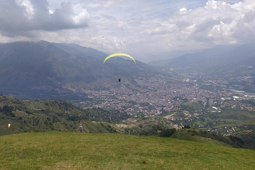 Scena di parapendio con paesaggio montuoso e una città in basso. 3