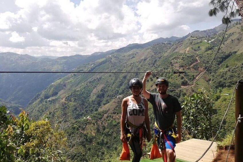 Dos personas en un sendero de montaña con una vista panorámica de colinas verdes y un cielo nublado. 5
