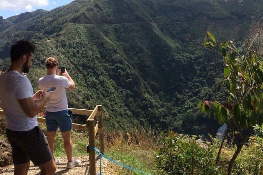 Dos personas en una plataforma de madera con vista a un paisaje montañoso. 1