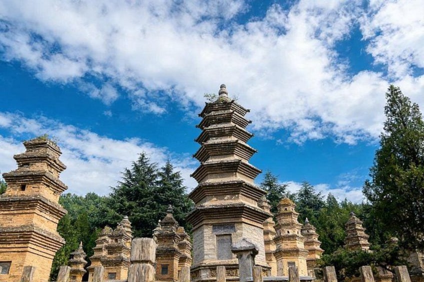 A series of tiered pagodas with a clear blue sky and trees in the background. 2
