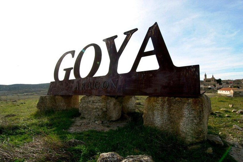 Un letrero de metal con el texto 'GOYA ARAGÓN' sujeto a bloques de piedra. 3