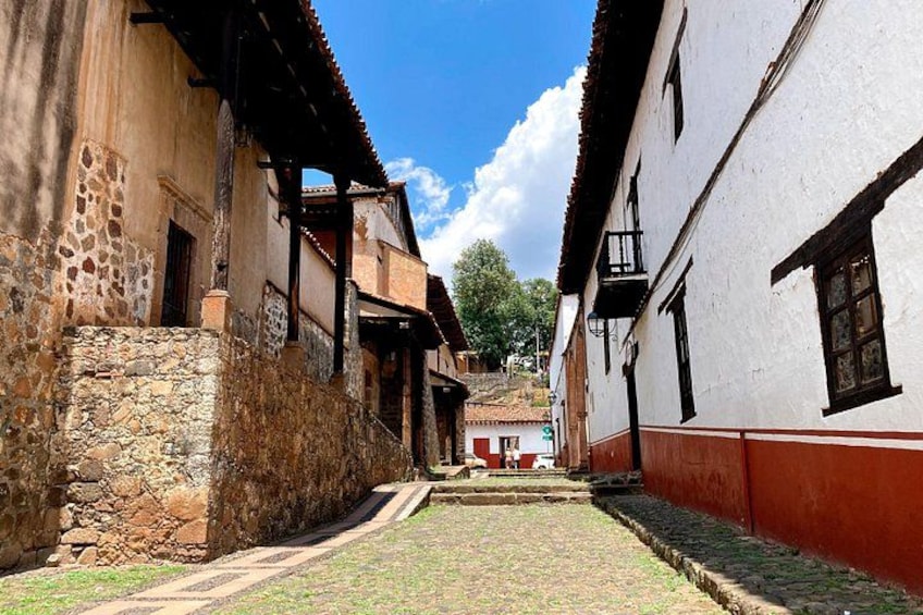Una stretta strada acciottolata fiancheggiata da edifici storici con muri in pietra e balconi in legno. 2