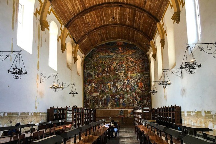 L’intérieur d’une église, avec des bancs en bois, un plafond haut et une grande fresque murale. 3