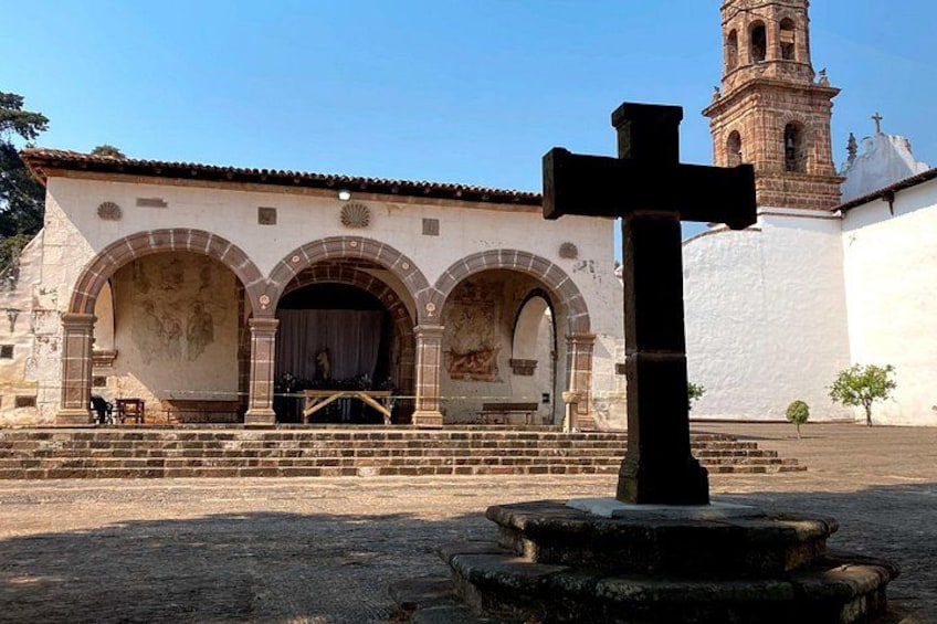 Une église dotée d’un clocher, d’une grande croix et d’une entrée en arc de cercle. 5