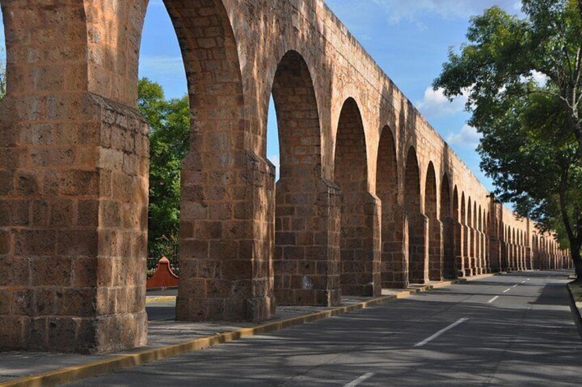 A long row of stone arches along a road. 4