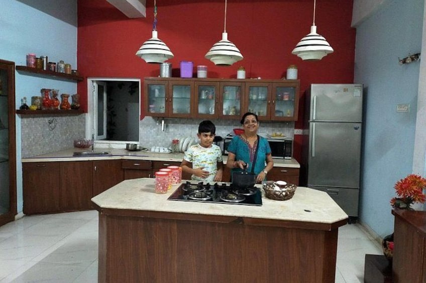 Una cocina con isla central, armarios de madera, un refrigerador y lámparas colgantes. 4