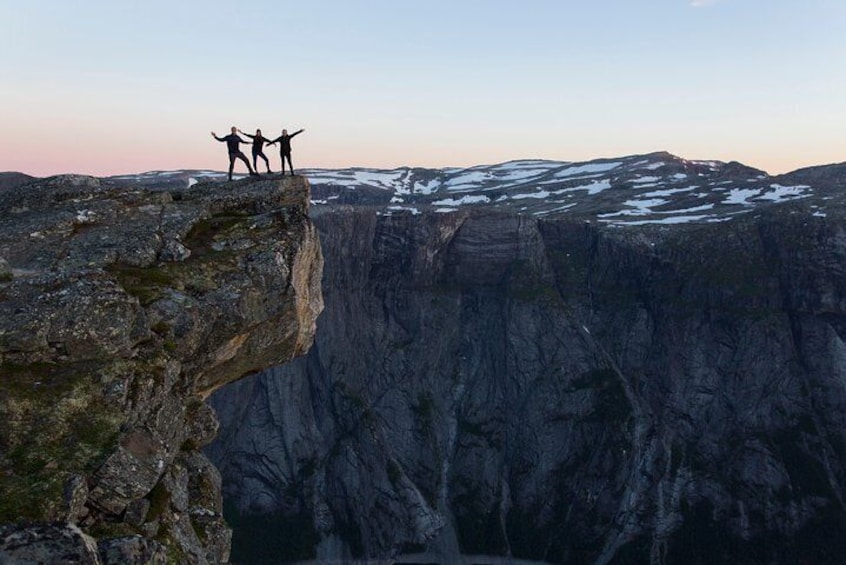 Deux personnes se tiennent au bord d’une falaise, avec un profond canyon en contrebas. 3