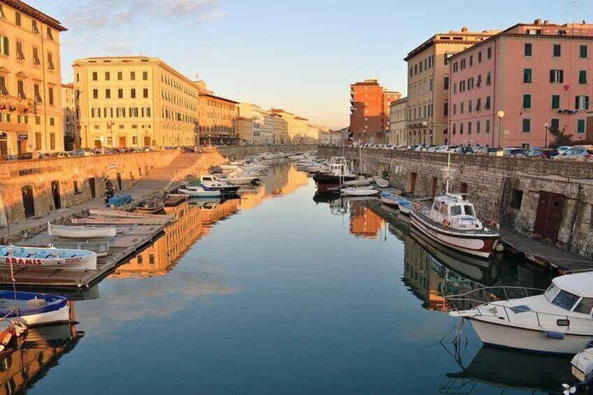 A canal with boats docked on both sides, surrounded by historic buildings. 1