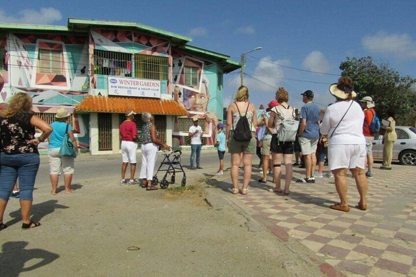 Un grupo de personas frente a un edificio con un letrero que dice 'Winter Garden Bar Restaurant & Nightclub'. 2
