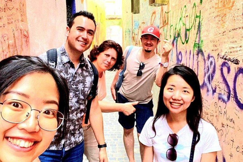 A group of people in an alley with graffiti on the walls. 2