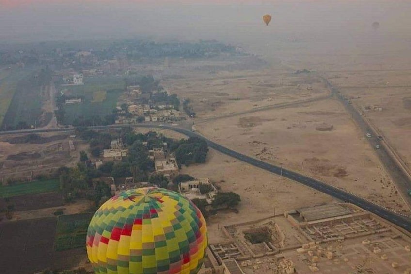 A hot air balloon, a road, and a distant cityscape. 3