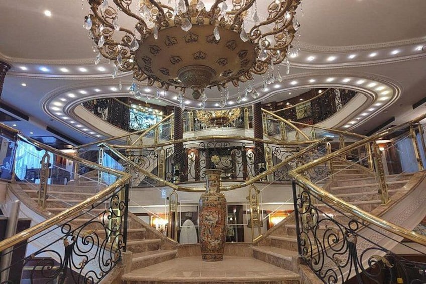 A grand staircase with ornate railings and a chandelier. 5