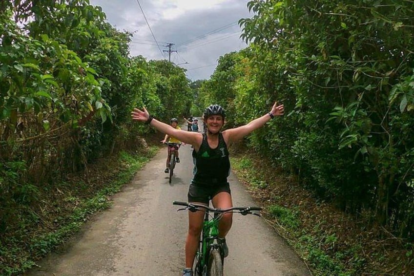 Un ciclista en un sendero estrecho rodeado de abundante vegetación. 3