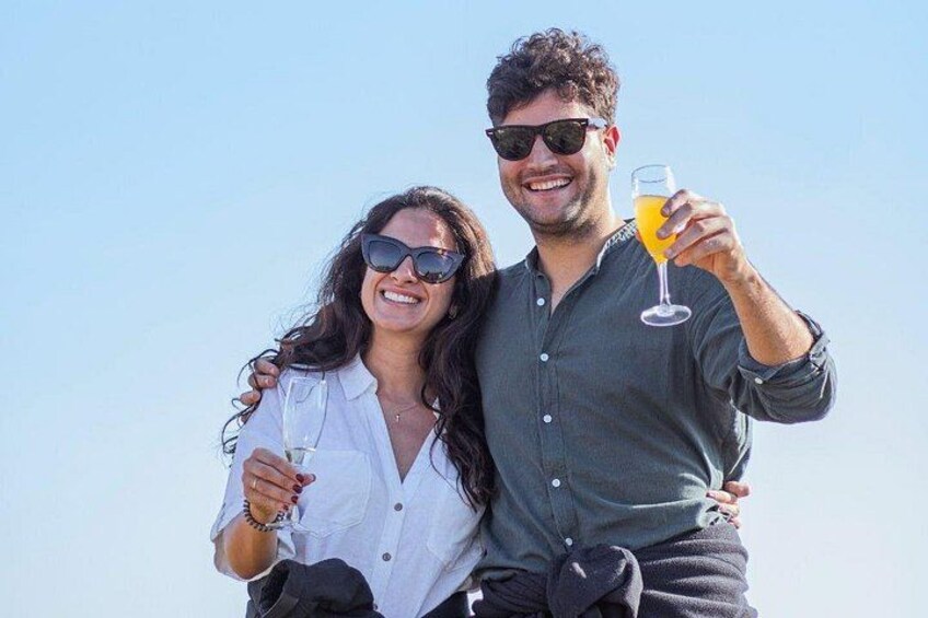 Two people standing outdoors, one holding a drink. 4