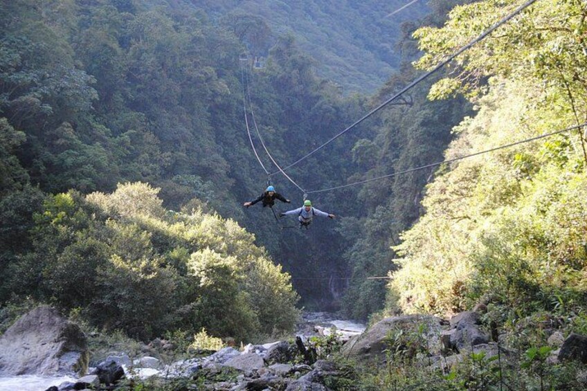 Una persona haciendo bungee jumping desde un risco alto con un valle boscoso abajo. 1