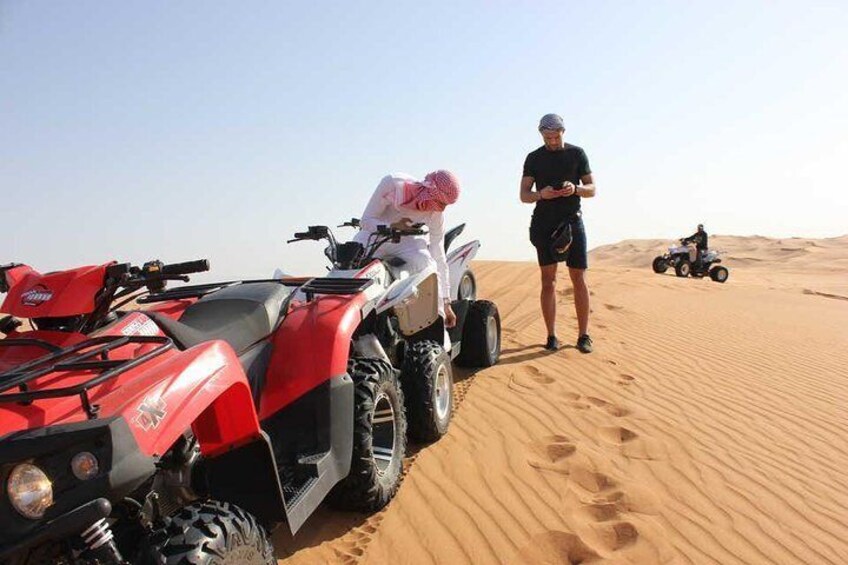 A desert landscape with ATVs parked on sand dunes. 1